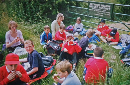 Group of teachers and children having lunch at the entrance gate